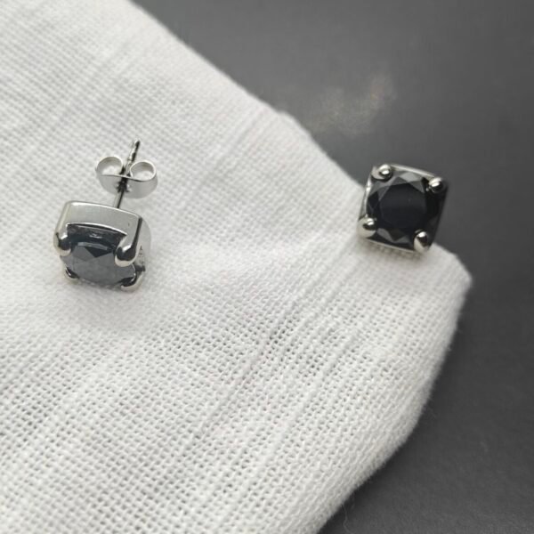 black stainless steel stud earrings for women on white cloth background