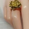“Magnolia petal-shaped gold-plated stainless steel ring with soft floral design on neutral background”