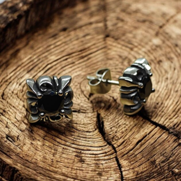 “Black stone stainless steel stud earrings with gothic-style design on rustic wood background”