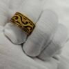 Gold plated stainless steel tribal pattern ring on white fabric
