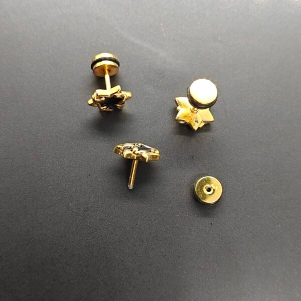 Gold-plated stainless steel star claw screw back earrings with black enamel accents on wooden surface