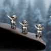 Silver stainless steel reindeer screw-back stud earrings displayed on wood with a snowy forest background.