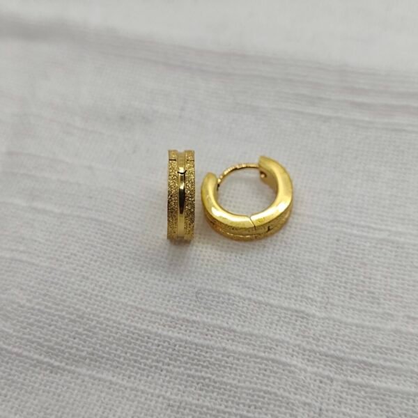 “Three pairs of small stainless steel hoop earrings in gold finishes displayed on a white fur surface.”