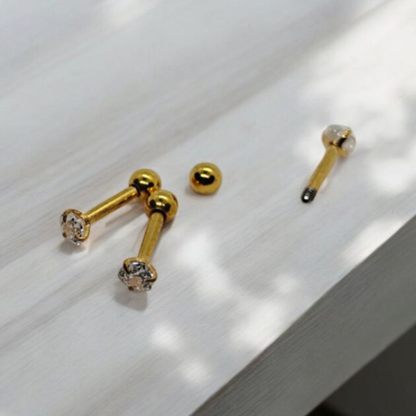 Stainless steel gold plated small heart crystal screw-back earrings on white fabric