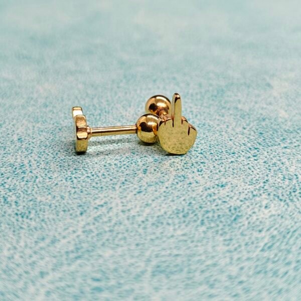 “Gold stainless steel middle finger screwback stud earring worn on ear.”