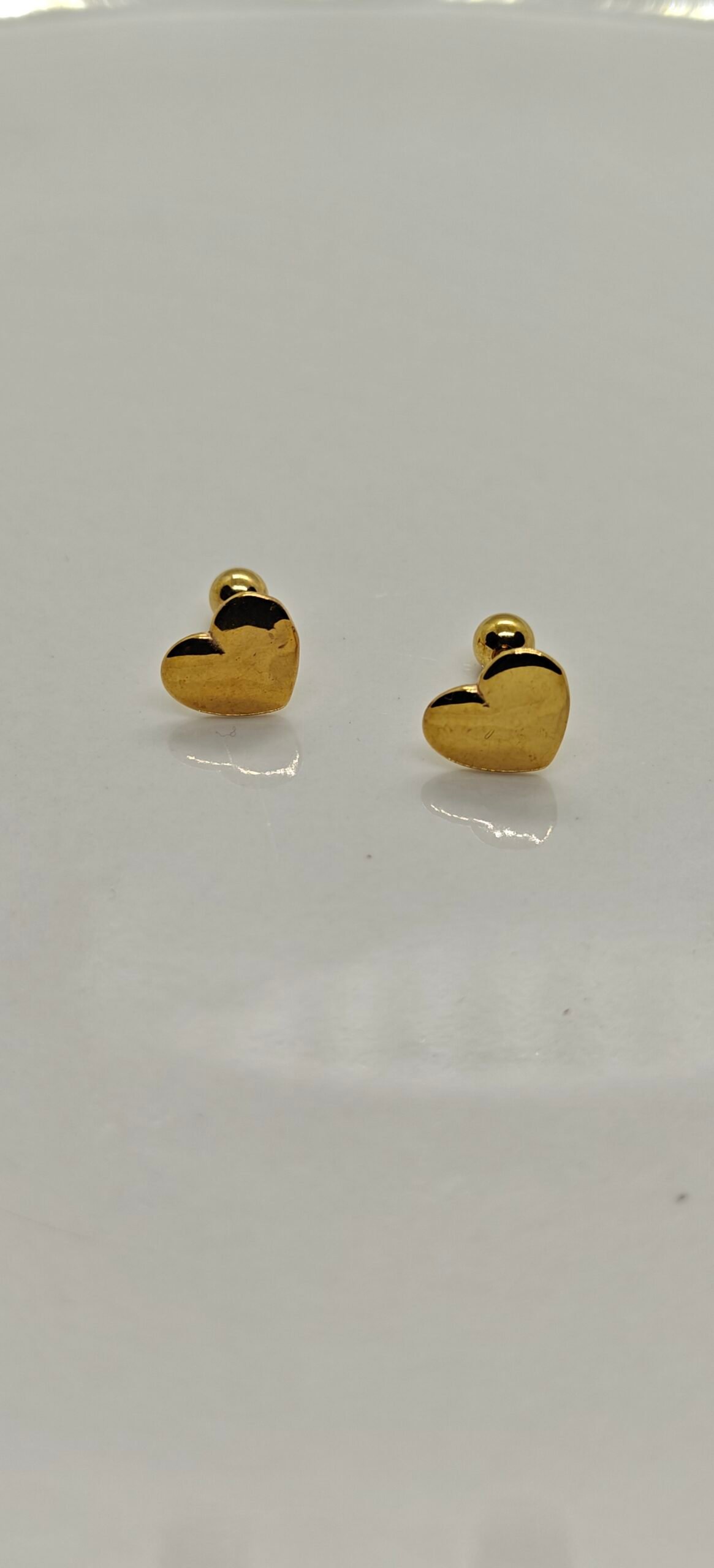 Gold heart screw back stainless steel gold plated earrings on white background