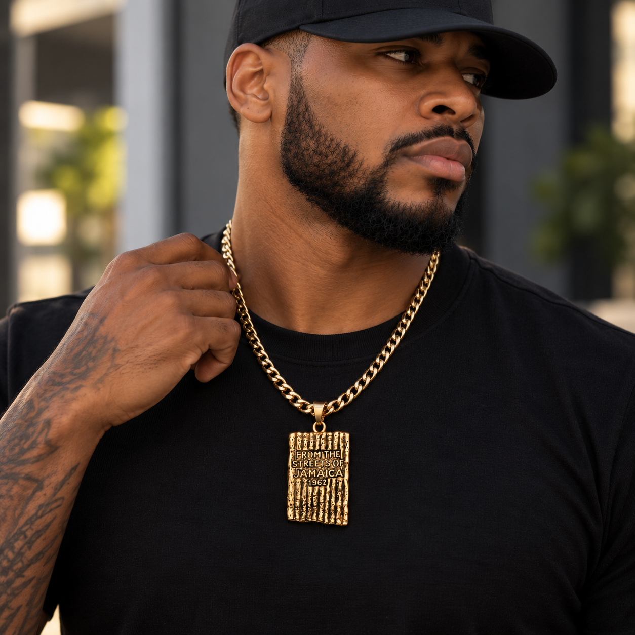 Man wearing gold Jamaica 1962 pendant necklace with Cuban link chain