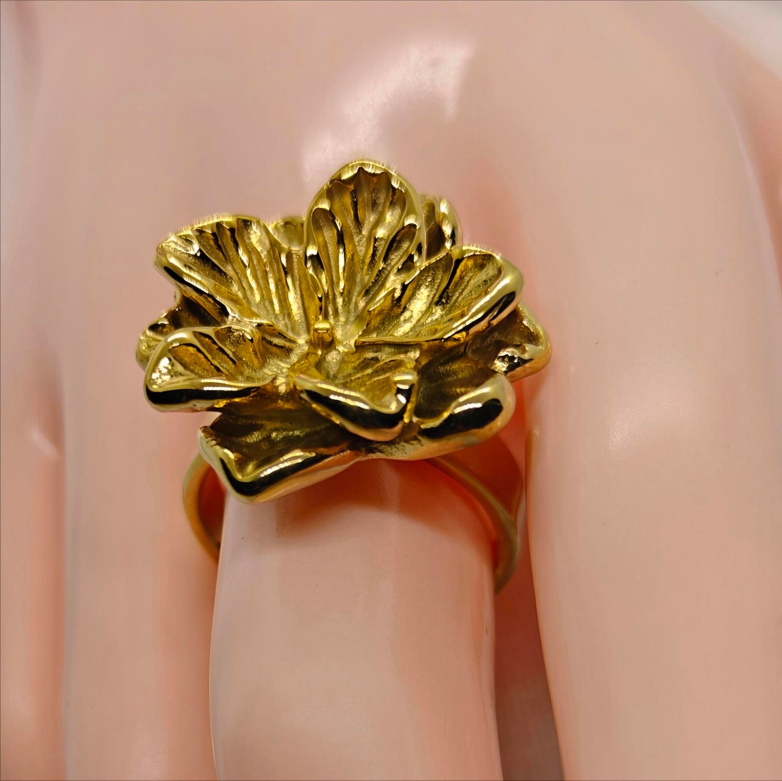 Woman wearing gold flower petal statement ring