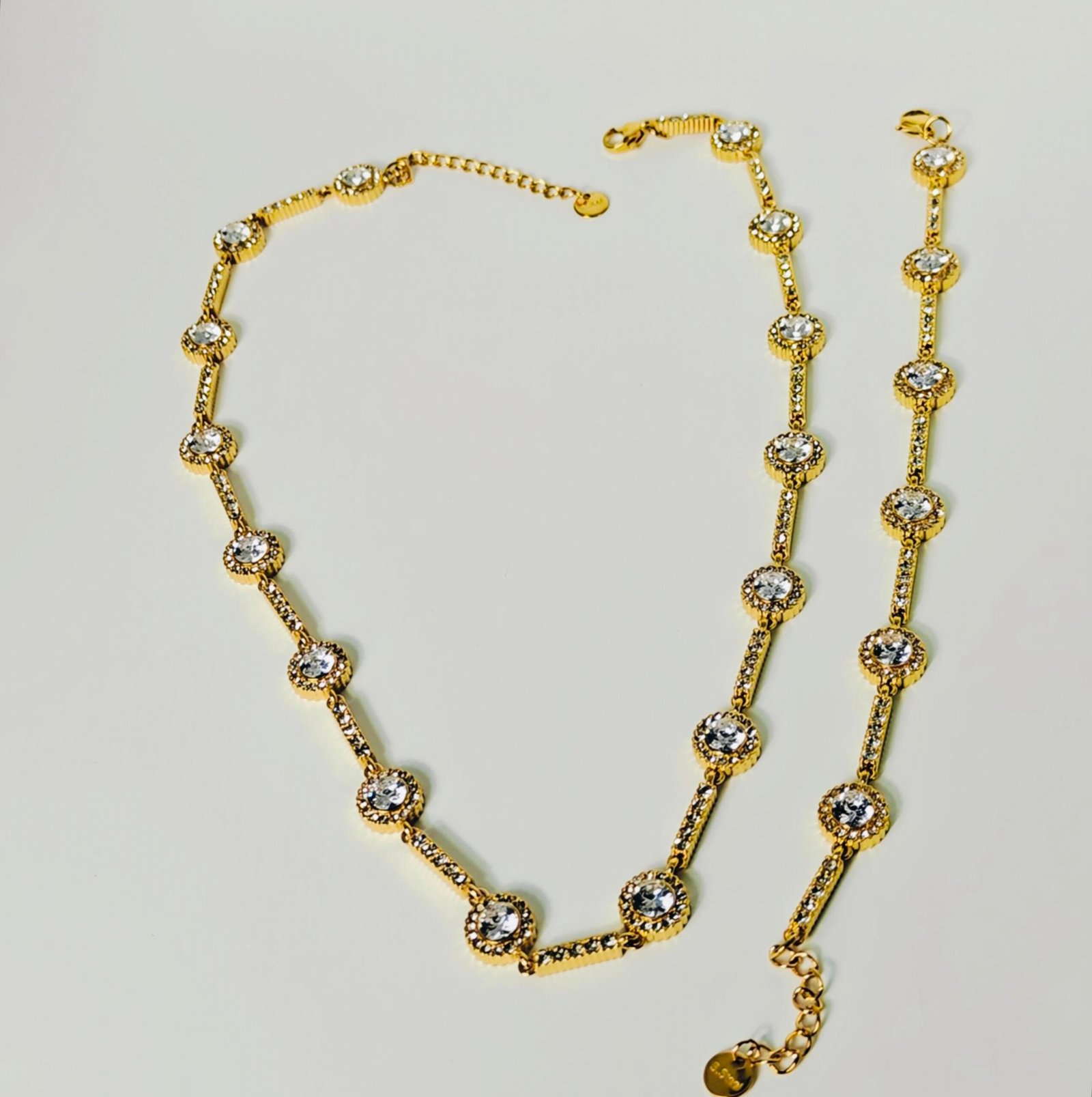 "HERDISE gold-tone crystal station necklace and matching bracelet featuring round sparkling accents."