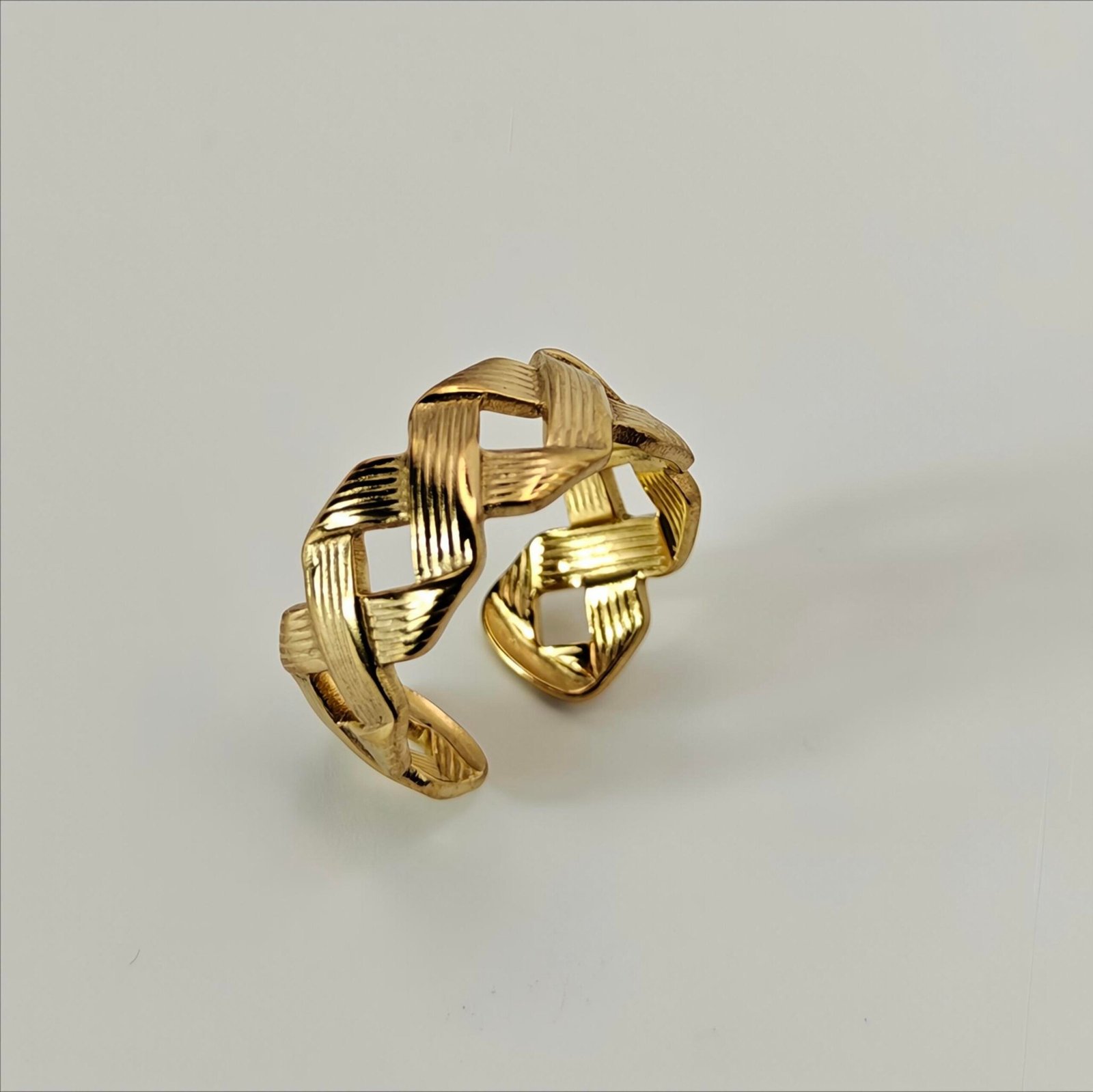 HERDISE Aurelia Weave gold-tone statement ring with textured interwoven ribbon design