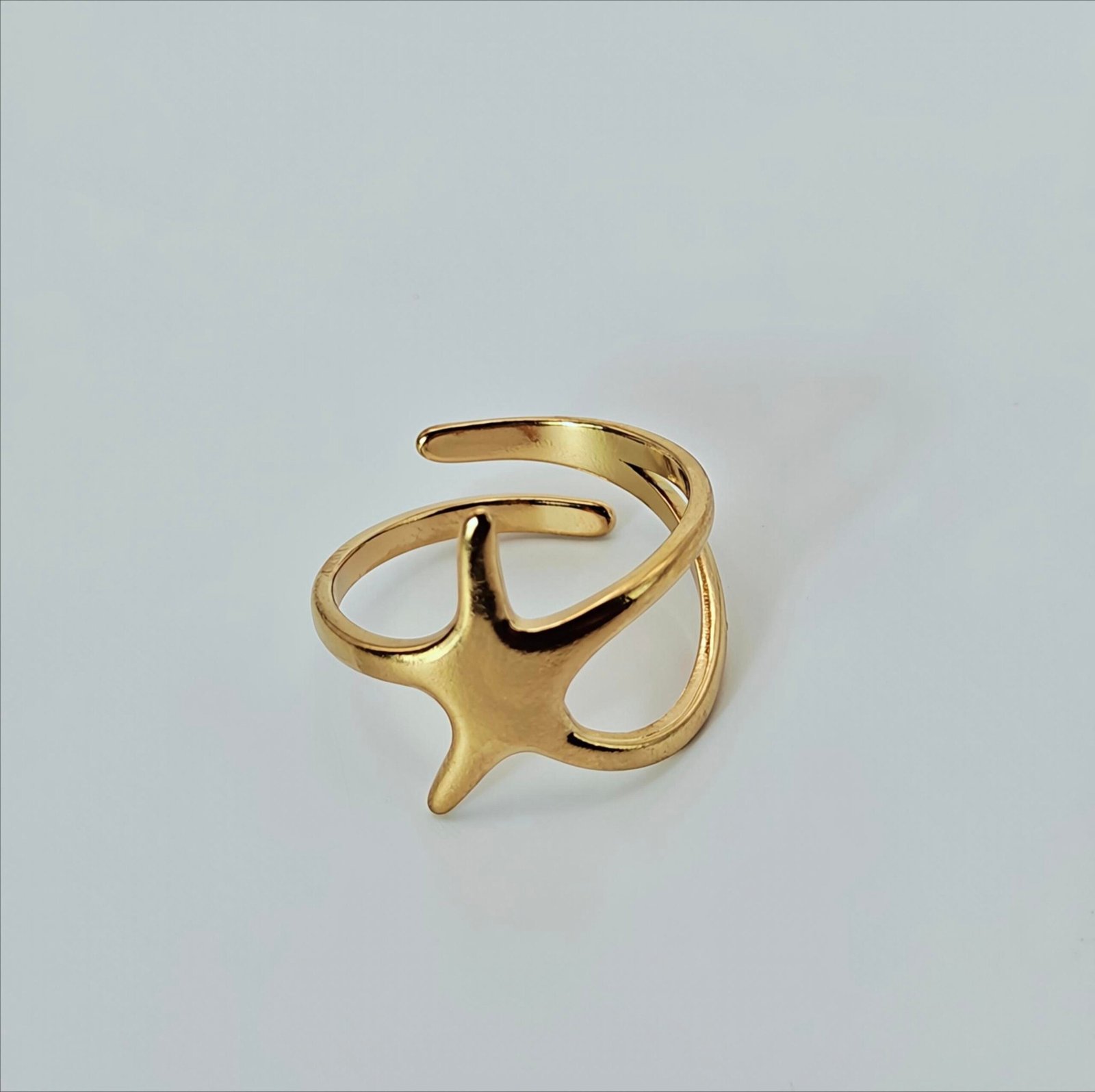 Size 9 Close-up of abstract four-point star centerpiece on polished gold-tone ring