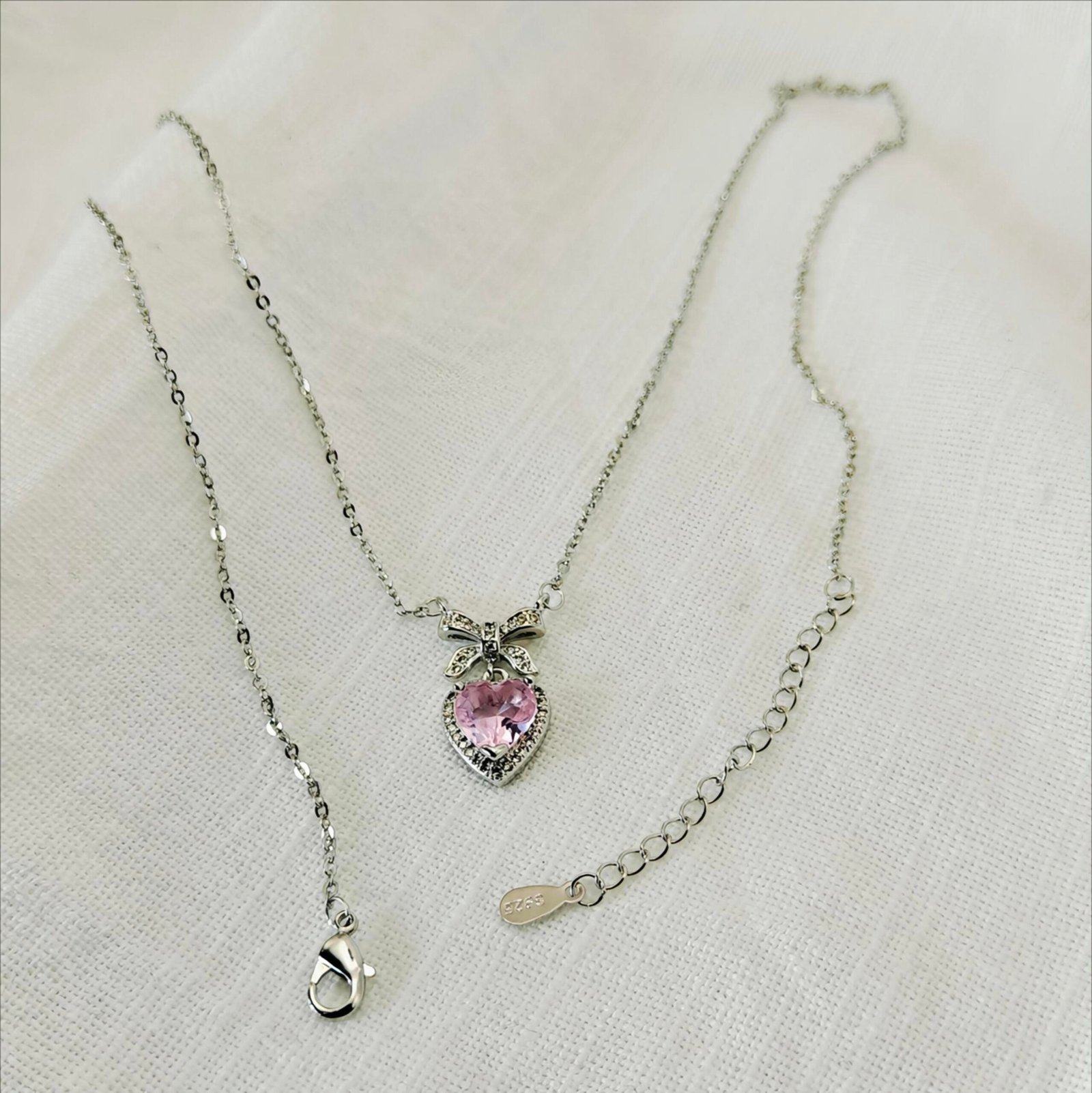 HERDISE Rosé Amour pink heart necklace with silver-tone bow and sparkling decorative accents